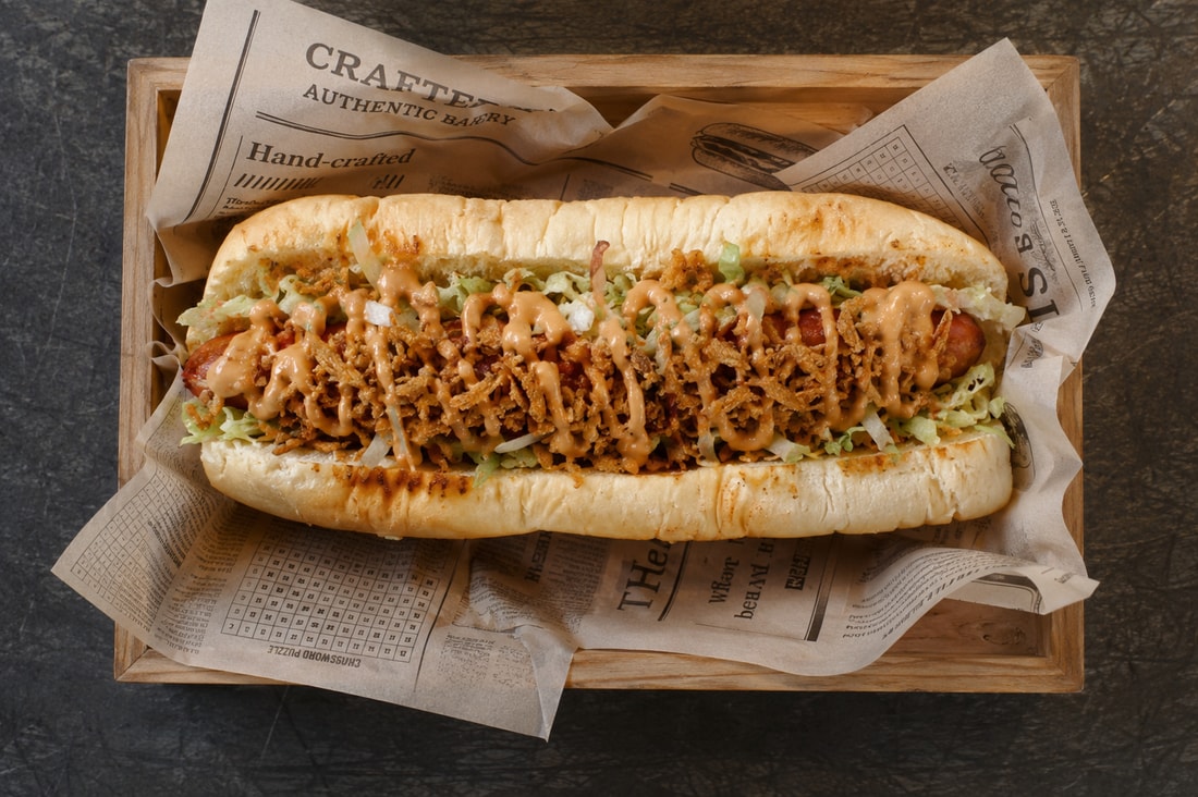 Marinski hot dog s sirom, slanino in ocvrto čebulo